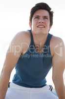 Exhausted man taking a break after jogging on beach