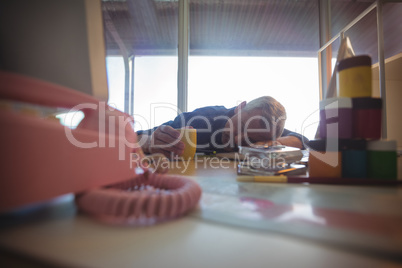 Tired businessman napping on office desk