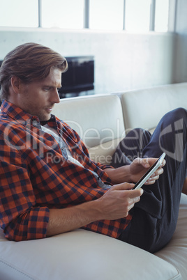 Businessman using mobile phone while resting on sofa