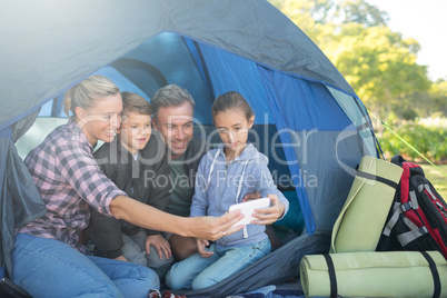 Family taking a selfie in the tent at campsite