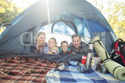 Smiling family lying in the tent