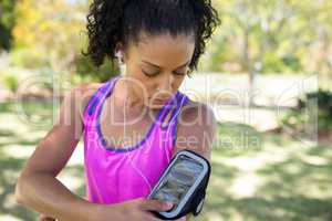 Jogger woman touching the mp3 player in armband