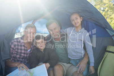 Smiling family sitting in the tent with the map