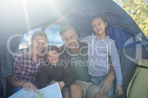 Smiling family sitting in the tent with the map