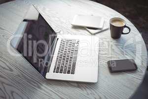Various technologies with coffee cup on desk in office