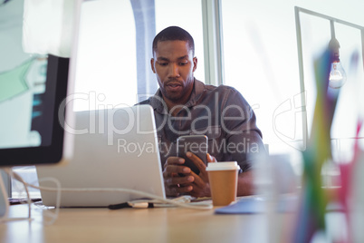 Young businessman using mobile phone in office