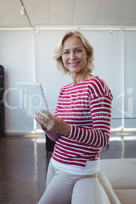 Portrait of smiling entrepreneur using digital tablet at office