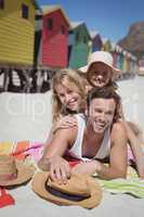 Portrait of happy family lying together on blanket at beach