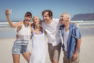 Cheerful family taking selfie at beach