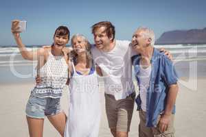 Cheerful family taking selfie at beach