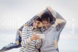 Happy young couple using mobile phone during winter