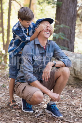 Playful boy covering fathers eyes while hiking