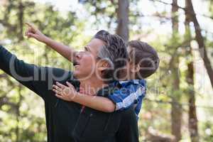 Father and son pointing away in forest