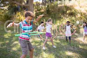Group of friends enjoying with hula hoops at campsite