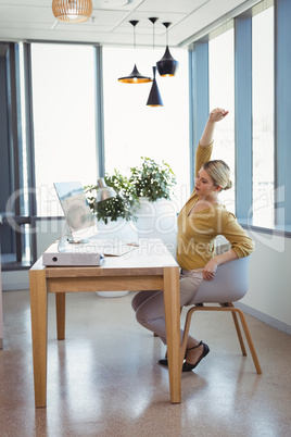Executive stretching her hands while working at desk