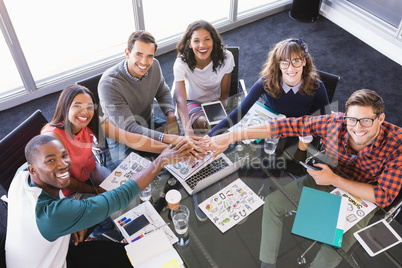 High angle portrait of happy business people stacking hands