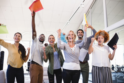 Cheerful business people with arms raised in office