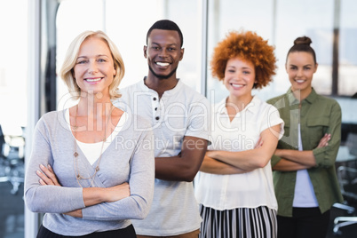 Portrait of smiling business people with arms crossed standing in row