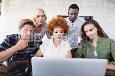 Business colleagues looking at laptop