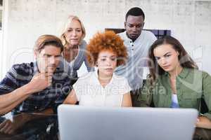 Business colleagues looking at laptop