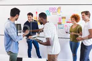 Business colleagues while standing against whiteboard