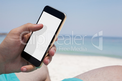 Close up of man using smartphone at beach