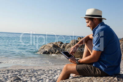 Man using digital tablet on the beach