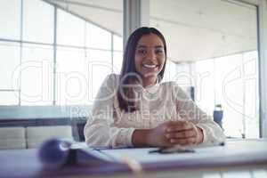 Young businesswoman sitting at workbench in office