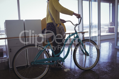 Businesswoman with bicycle creative office