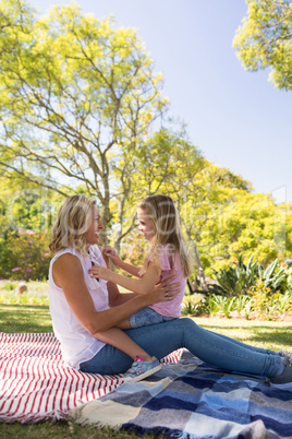 Happy mother embracing her daughter in park