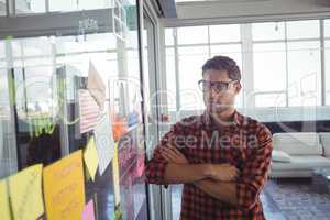 Thoughtful businessman looking at adhesive notes in office