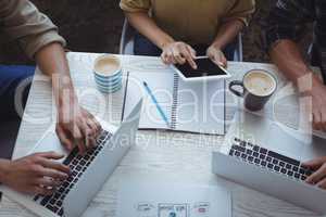 Creative team using laptop and digital tablet while planning in office