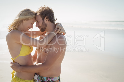 Side view of young couple embracing at beach