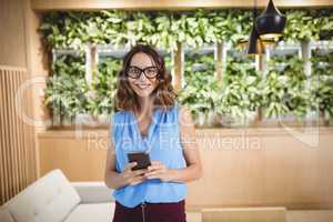 Portrait of smiling executive using mobile phone