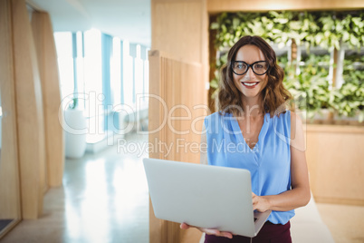 Portrait of smiling executive using laptop