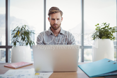 Attentive executive using laptop at desk