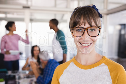 Portrait of smiling businesswoman with colleagues in office