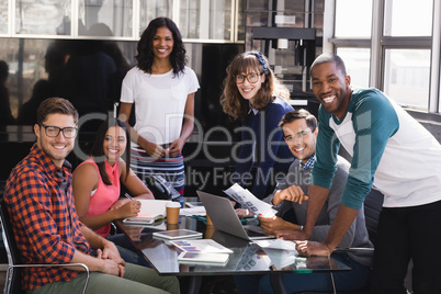 Portrait of smiling colleagues at desk