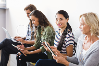 Portrait of businesswoman sitting by colleagues