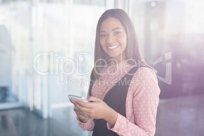 Portrait of smiling businesswoman using mobile
