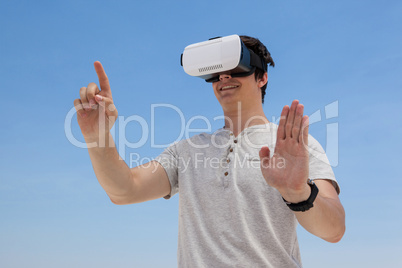 Man using vr headset against the blue sky