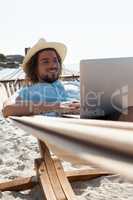 Man using laptop while relaxing on hammock