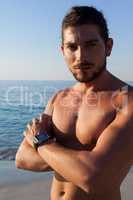 Portrait of shirtless muscular man standing at beach