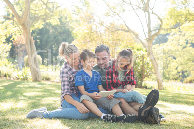 Family using digital tablet in the park