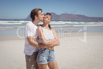 Young man kissing woman at beach