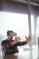 Businessman using virtual reality headset in office