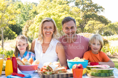 Portrait of happy family having meal in park