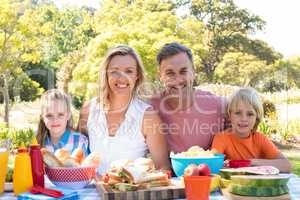 Portrait of happy family having meal in park