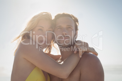 Thoughtful couple embracing at beach