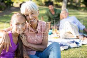 Portrait of grandmother and granddaughter sitting in the park